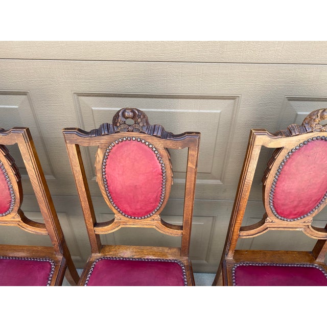 Set of 6 Louis XVI style French carved bow-top antique chairs with red leather upholstery. The backs are brown leather on...