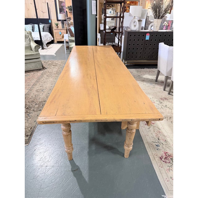 An exceptional example of early 1900s English country-house furniture, this antique pine farmhouse dining table carries...
