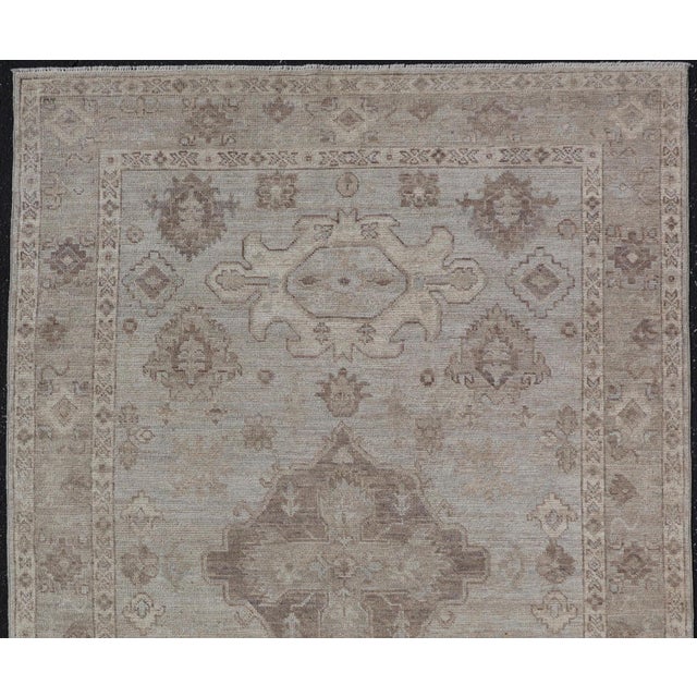 Measures: 4'11 x 7'8 Modern Oushak Rug with Lt Blue Field and Warm Brown Medallion Design 4'11 x 7'8. Keivan Woven Arts /...
