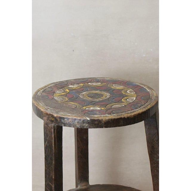 Vintage Ethiopian coffee table, characterized by its rustic wooden construction, two-tiered design, and a striking top...