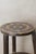 Vintage Ethiopian coffee table, characterized by its rustic wooden construction, two-tiered design, and a striking top...