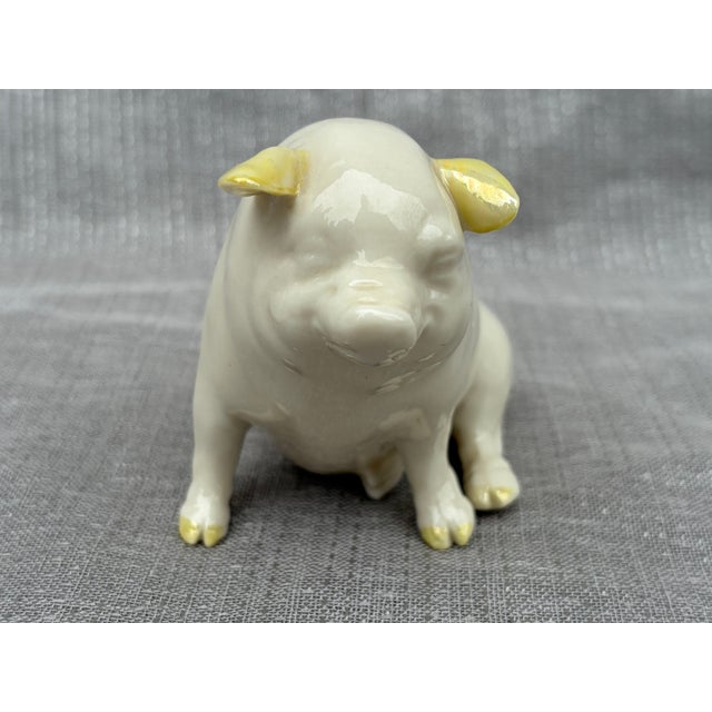 Sweet vintage ivory Belleek porcelain pig with pale yellow ears. Marked on the bottom. Pig measures 4" by 2" by 3".