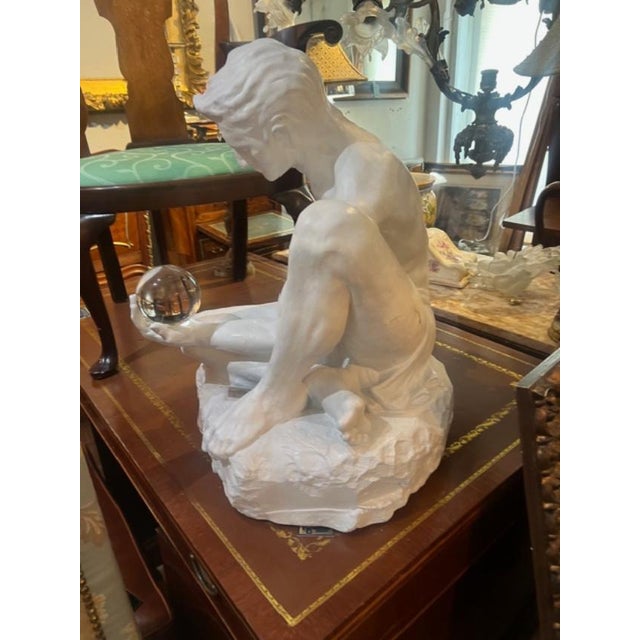 This product is a large stone sculpture of a nude man holding a crystal ball. Handmade in 1970, the white stone material...
