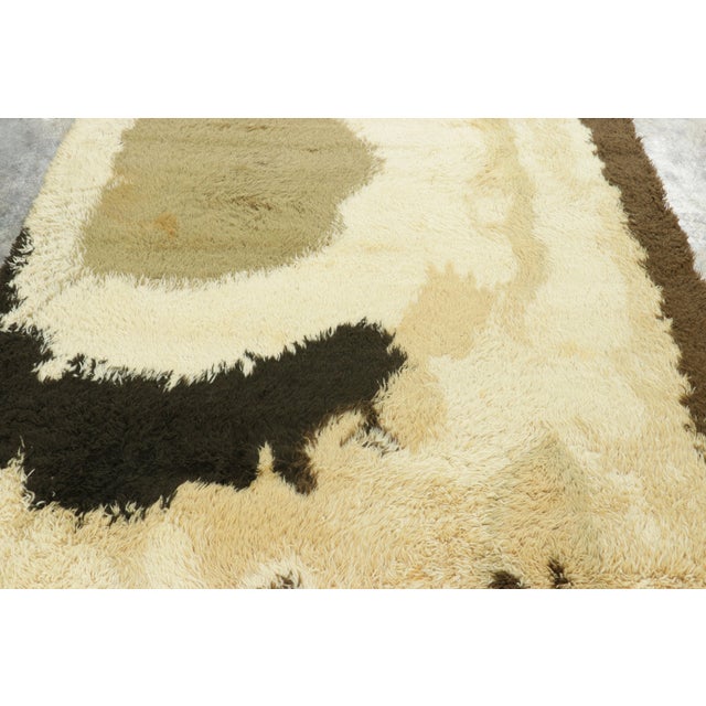 Hand-knotted in lush, high-pile wool in Sweden circa 1960-1970, this 6x9 vintage Swedish Rya rug is a bold new addition to...