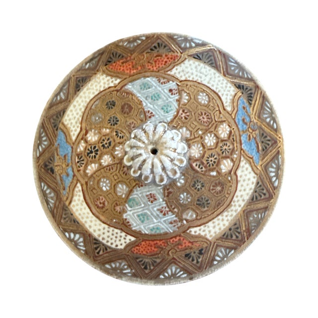 A finely decorated Japanese Satsuma style lidded jar featuring an intricate figural scene with layered gilt and raised...
