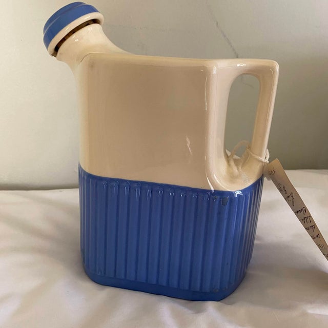 This is a farmhouse-style jug made by Universal Potteries Inc. operated in Cambridge, Ohio from 1934-1956. It is a cream...