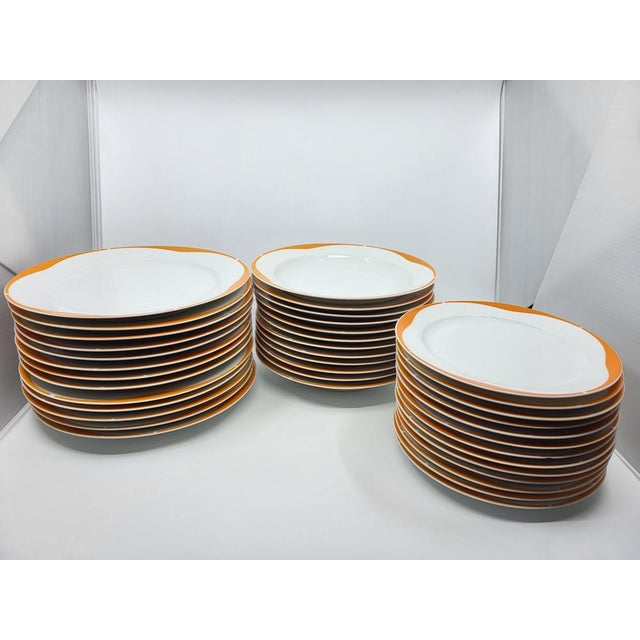 White and orange porcelain service of 73 pieces. It consists of: 13 dinner plates 12 soup plates 13 dessert plates 1 large...