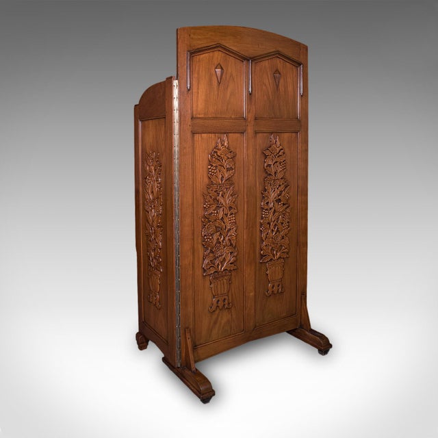 This is a large vintage dressing screen. An Oriental, mahogany folding privacy screen or room divider, dating to the late...