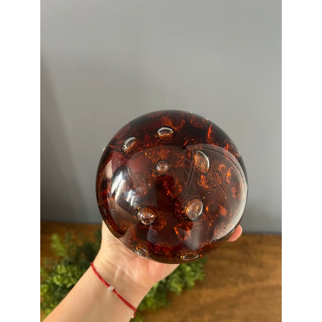 Oversized controlled bubble amber paperweight. It’s a stunning deep dark amber color paperweight with beautiful large...
