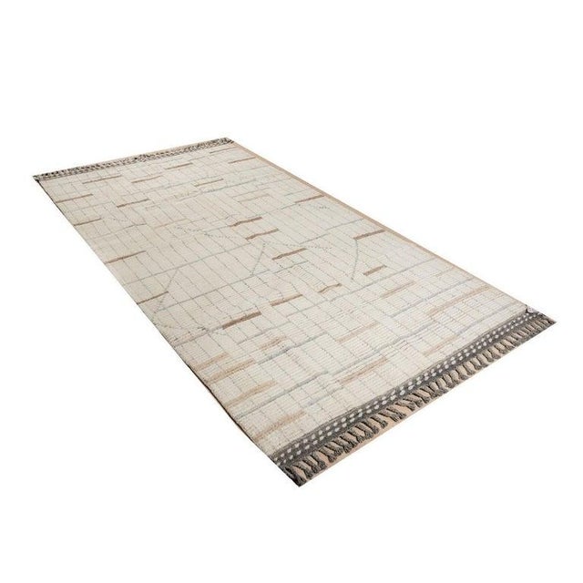 This hand knotted pile rug features a primary color palette of ivory, beige, cream, and white. Constructed from high-...