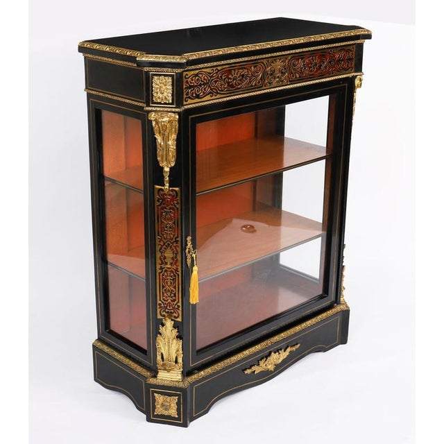 This is a beautiful antique French Napoleon III ebonized and cut brass marquetry red Boulle pier cabinet, circa 1860 in...