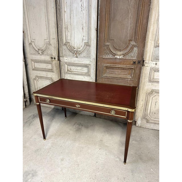 Small louis xvi style flat desk or writing table in mahogany and mahogany veneer, circa 1950. The top is covered in...