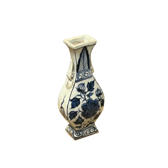 This small porcelain vase features a classic blue-and-white design characterized by a pear-shaped body, a slender neck,...