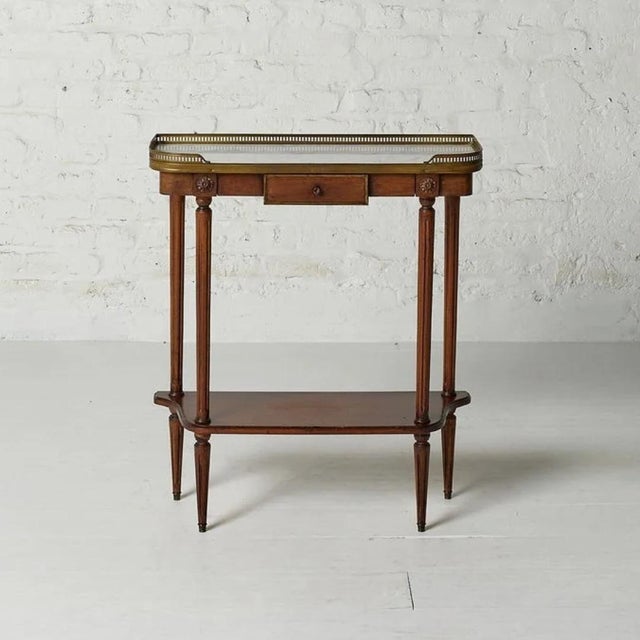 This exquisite 18th-century Louis XVI console table embodies timeless French elegance with its rich mahogany construction,...