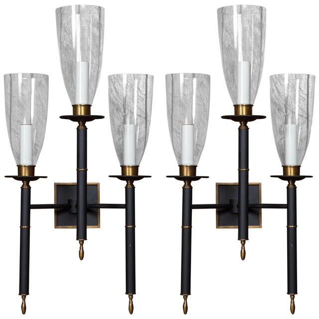 Pair of triple glass hurricane black tole sconces with brass trim. New stock from the 1960s.