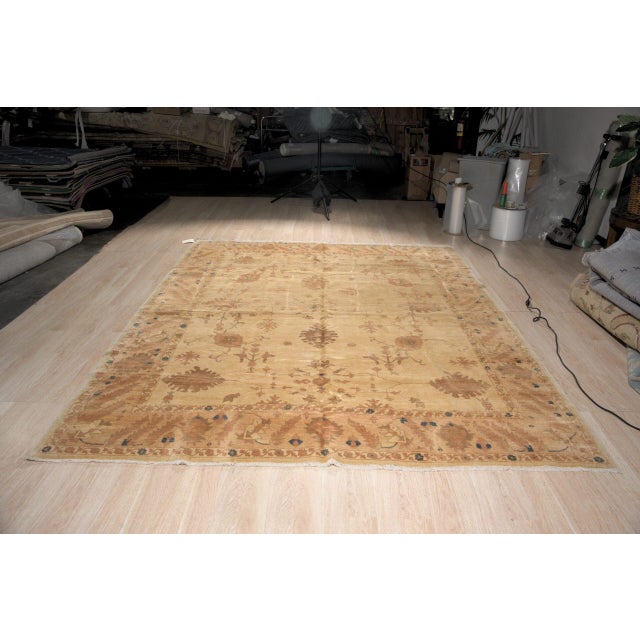 Peshawar rug in soft, sun washed colours. Large rust and terracotta palmettes and blossoms in the Oushak style are...