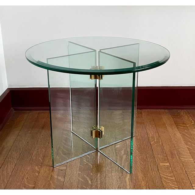 Beautiful 1970s side or end table by Leon Rosen for Pace. The table is round, primarily made of glass with brass hinges....