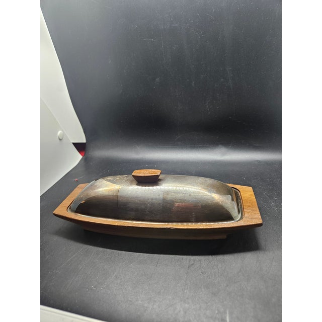 vintage mid-century modern butter dish features a stainless steel cover and a wooden base with teak