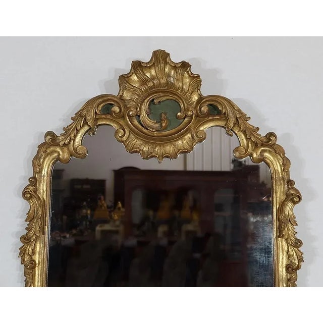 Superb rocky style mirror summoned with a majestic pediment forming a large shell with asymmetrical volute characteristic...