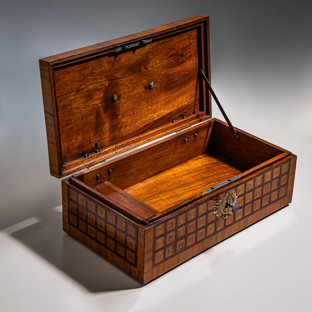 Rectangular cherrywood box with square parquetry in various woods. The lid is fitted with a bronze key escutcheon and...