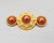1990s goldtone faux-red pearl center surrounded by studs with two round pearls with goldtone rope design around them on...