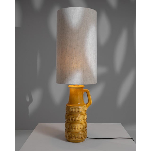 Illuminate your living space with this vibrant 20th-century German ceramic table lamp, showcasing a bold and sunny yellow...