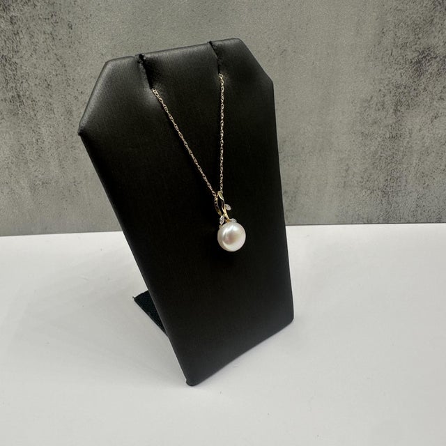 This elegant pearl and diamond necklace in 10kt yellow gold features an approximately 8.3mm lustrous pearl accented by...