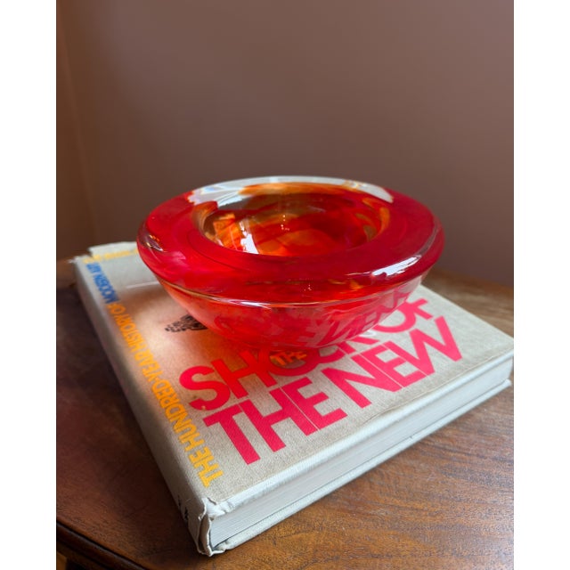 Vividly colored Kosta Boda Atoll bowl designed by Anna Ehrner. Collectible Swedish art glass in swirling red and orange....
