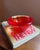 Vividly colored Kosta Boda Atoll bowl designed by Anna Ehrner. Collectible Swedish art glass in swirling red and orange....