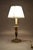 A refined vintage brass table lamp with an elegant candlestick silhouette, accented by a deep green decorative detail and...