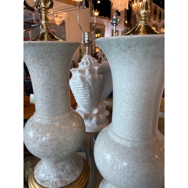 Lovely vintage pair of crackle porcelain table lamps. Gold gilt wood base with brass top. Newly wired, clear cords, 3 way...