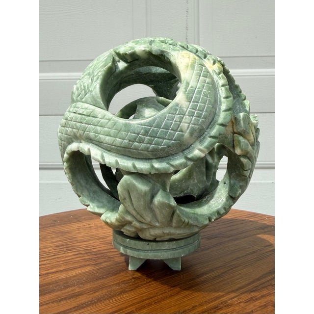 This stunning piece is a true work of art, hand-carved from natural green jade into a mesmerizing puzzle sphere. At first...