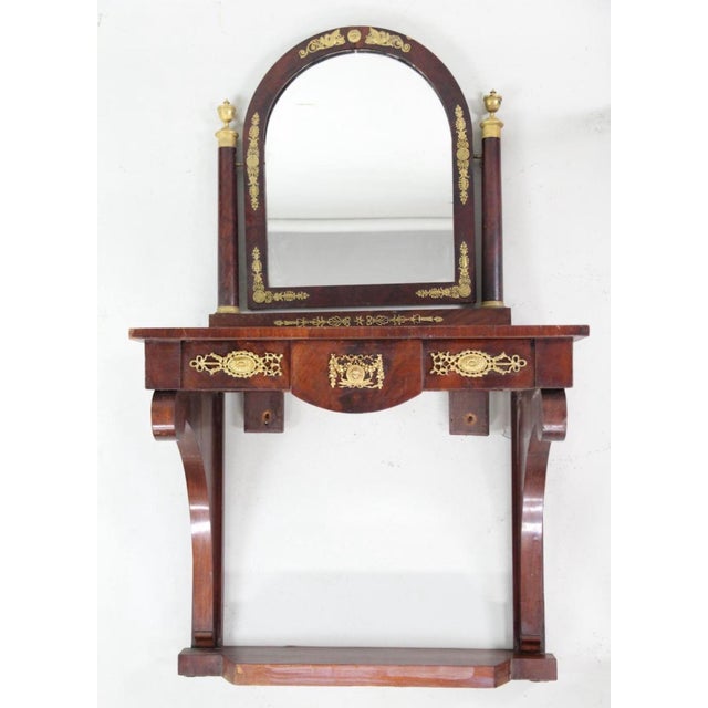 Mirrored Pier Table with Gilt Applique. Wall mounted table with mirror, veneered in figured wood and lavishly decorated in...