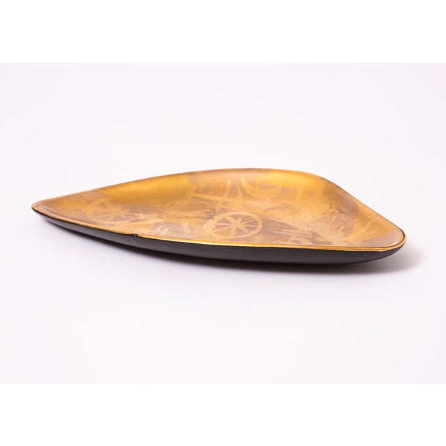 Kidney shaped dish featuring an abstract primitive gold and bronze hand painted design. It is from the "More Gold"...