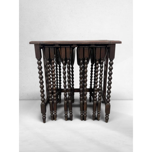 A rare antique circa 1920s Jacobean Revival bobbin nesting table suite, featuring a larger host table with four individual...