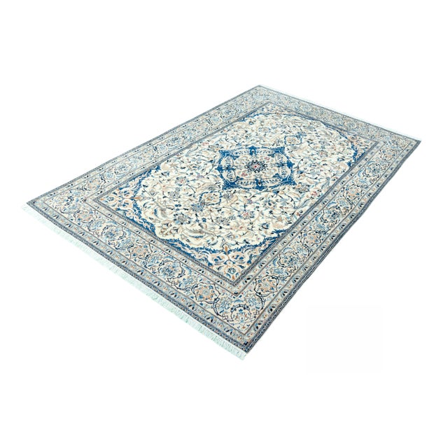 A classic Nain rug in 9La quality - hand-knotted from fine virgin wool with fine silk components that provide elegant...