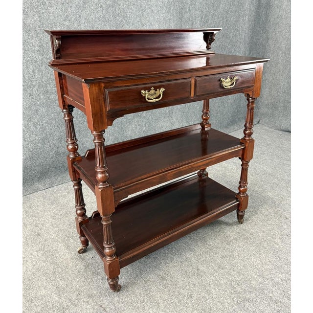 This 19th century mahogany three-tier server features a molded gallery back, two drawers with brass pulls, and turned...