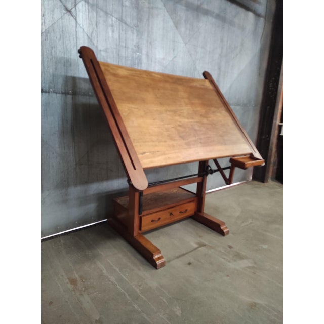 This vintage drafting table, likely by Raoul Simon, combines craftsmanship with clever engineering. The solid wooden base...