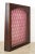 Vintage slanted display case made of a dark wood frame with pink and red floral fabric lined inside. The hardware is made...