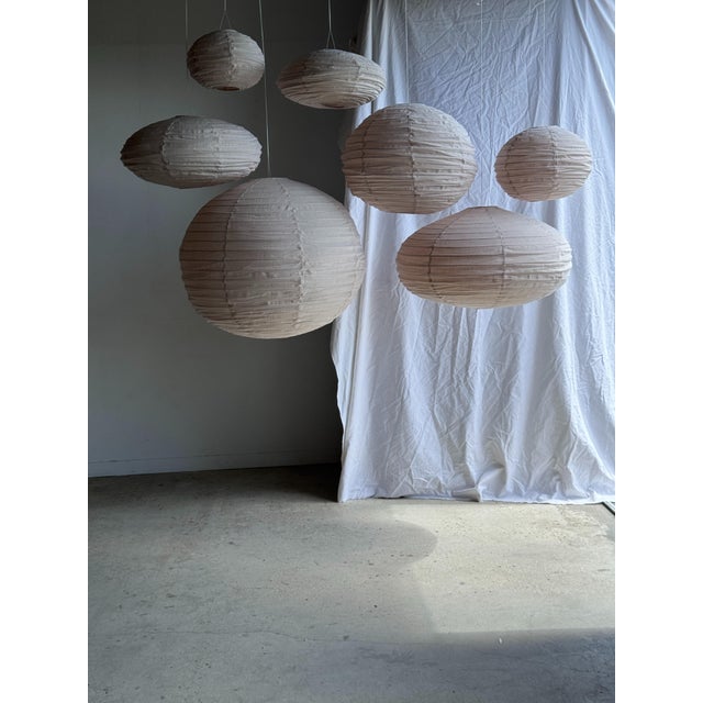 Medium-sized, round, pale pink Japanese-style rattan and natural linen pendant light. Beautifully handcrafted: natural...