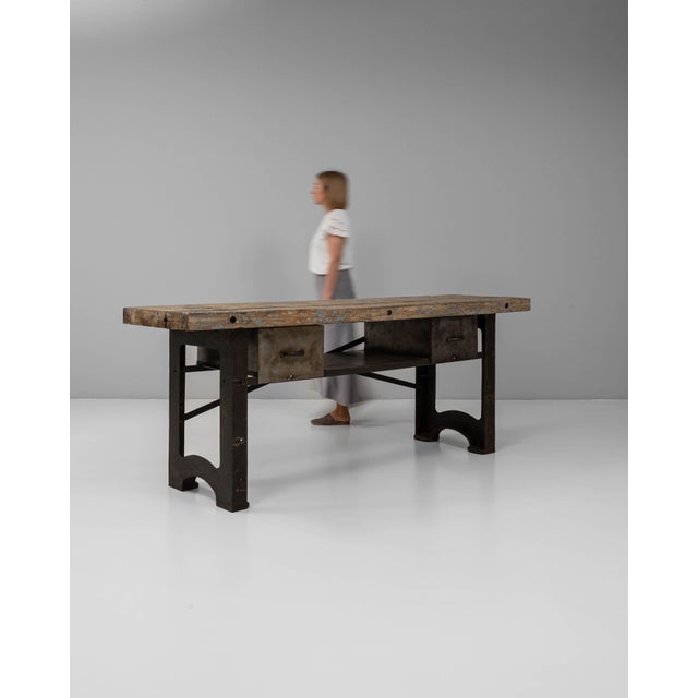 This 20th Century French industrial cast iron work table with wooden top is a powerful example of early factory...