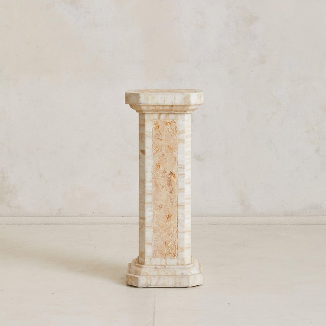 An Italian pedestal from the 1970s, sculpted from creamy travertine with warm ochre veining. Four inlaid panels run...