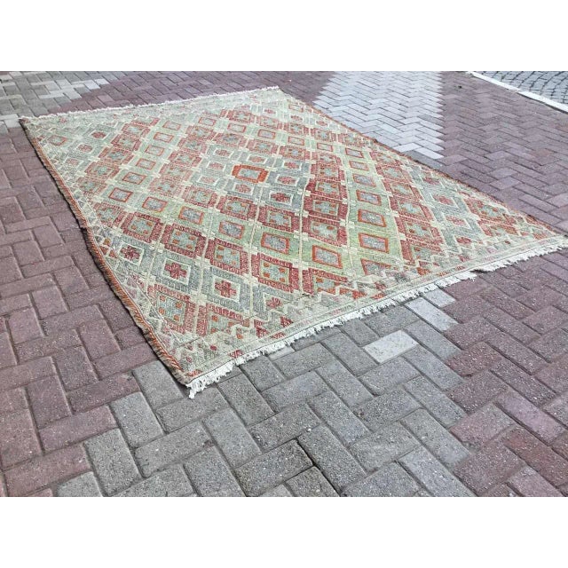 This beautiful, traditional vintage, flatweaved Turkish kilim rug is approximately 60 years old. It is handmade of very...