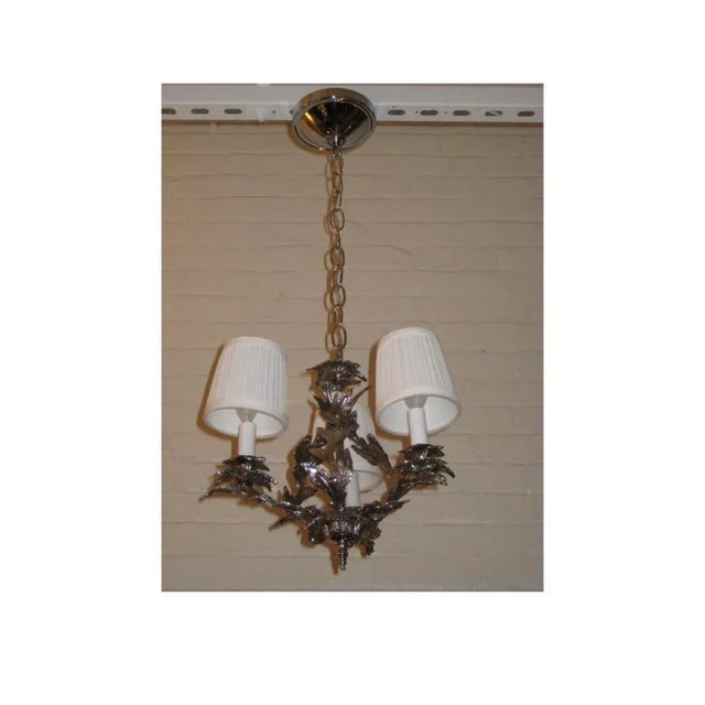 Metal frame of leaves and vines plated in nickel, with new wiring and sockets.