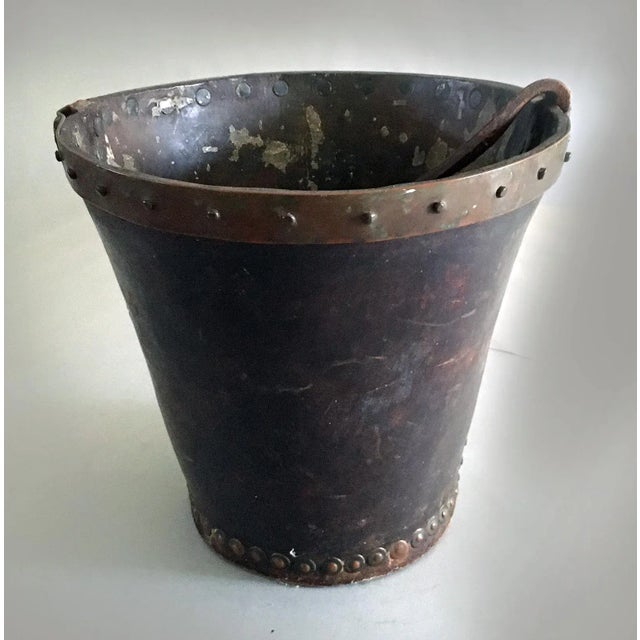 English leather and copper bound fire bucket with original strap handle and copper rivets. The heavy leather body is in...