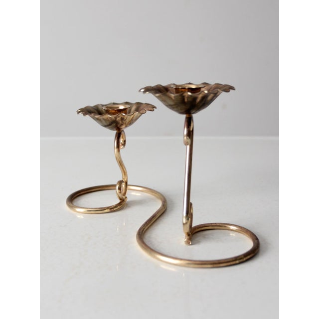This vintage brass tone candleholder is a beautiful and elegant piece. Featuring a flower-shaped base and a curved stem...