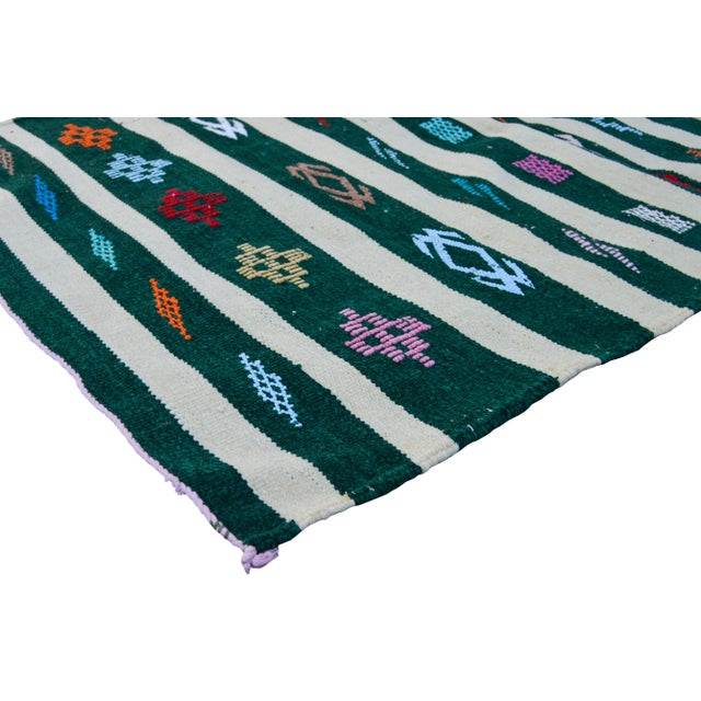 Vintage handwoven Moroccan Berber kilim with geometric shapes, stripes and symbols of nature.