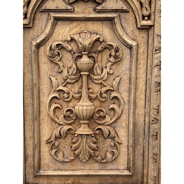 Hand-carved solid wood wall panel depicting a crest in deep relief, framed by an architectural border. The carving shows...