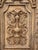 Hand-carved solid wood wall panel depicting a crest in deep relief, framed by an architectural border. The carving shows...