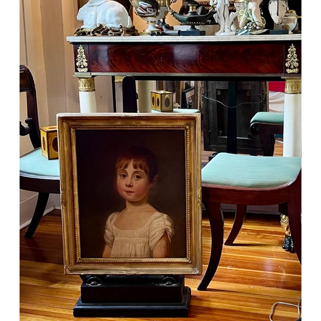 Antique early 19th century American oil painting on canvas portrait of a young girl in original giltwood frame. She has an...